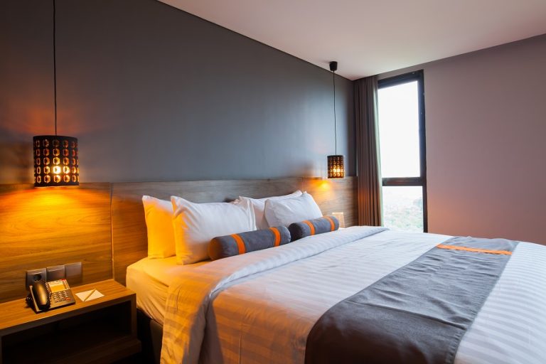 Interior of modern bedroom at hotel with white bed and pillow